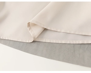 Detailed view of fine stitching on beige woven fabric with grey inner lining detail