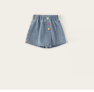 Dettaglio della gonna-pantalone in denim per bambine con bottoni colorati decorativi