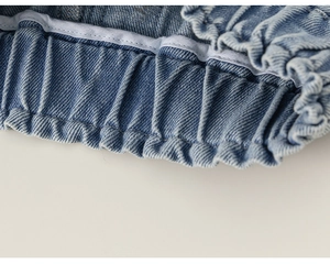 Dettaglio ravvicinato della vita elastica su pantaloncini di jeans azzurri da bambina con cuciture