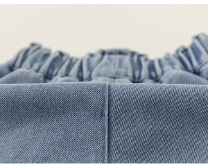 Dettaglio degli shorts in denim azzurro da bambina con vita elastica e trama in twill