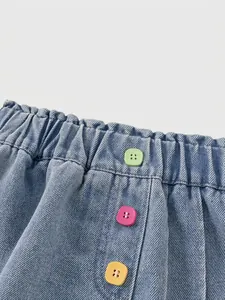 Pantaloncini di jeans celeste da bambina con vita elastica e tre bottoni colorati