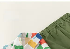 Detail of cartoon print collar and green elastic waistband on boys cotton summer outfit
