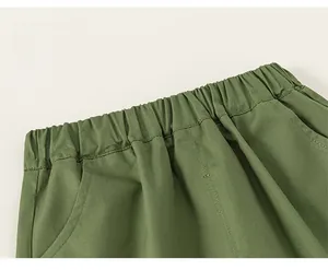 Detail of army green boys' shorts showing elastic waistband and fine stitching craft