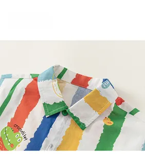 Detail of boys colorful striped shirt with cartoon crocodile print and green buttons