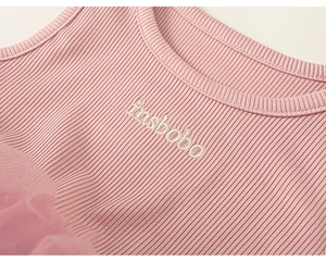 Close-up of pink ribbed fabric, round neckline, and embroidery on a girl's tutu dress