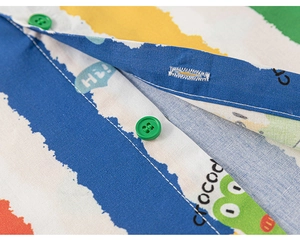 Close-up of colorful striped shirt with green crocodile print and emerald buttons