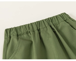 Detailed close-up of elastic waistband and side pocket on boys' army green cotton shorts