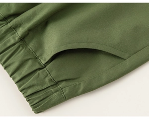 Detailed view of elastic waist and side pockets on olive green cotton shorts for boys