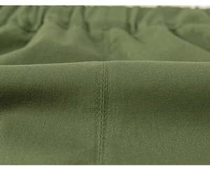 Detailed macro view of olive green twill fabric with elastic waistband and double stitching