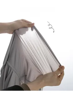 Détail du tissu en maille grise montrant l'élasticité et la respirabilité d'une veste enfant