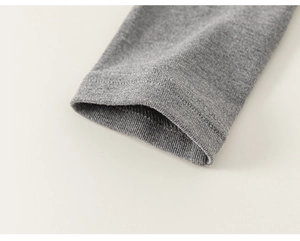 Detailopname van grijze gebreide broek met focus op geribbelde manchetten en afwerking