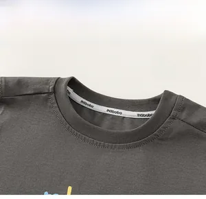 Détail de l'encolure ronde classique avec ruban de renfort sur un t-shirt en coton gris