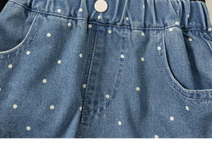 Detailansicht der Jeans-Shorts mit weißen Punkten und elastischem Bund mit Knopf