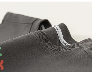 Gros plan sur l'encolure en tricot de coton gris foncé avec coutures et bordures côtelées