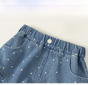 Detail von Elastikbund und Zierknopf an blauen Polka-Dot Denim-Shorts für Mädchen