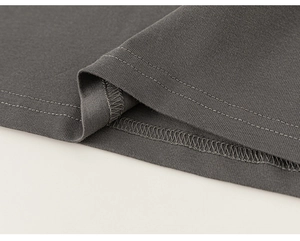 Détail de couture à double aiguille et surjet sur l'ourlet en maille gris foncé