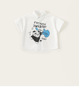 Close-up of boys white cotton shirt featuring a guitar-playing dog cartoon print
