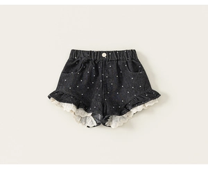 Nahaufnahme schwarzer gepunkteter Denim-Shorts mit weißem Spitzenbesatz und Rüschensaum