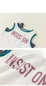 Détail d'un haut sans manches blanc avec bordure verte et inscription violette
