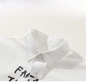 Detail shot of white cotton boy shirt collar with buttons and graphic text print
