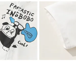 Detail of white boy's shirt showing the colorful cartoon dog print and sleeve stitching