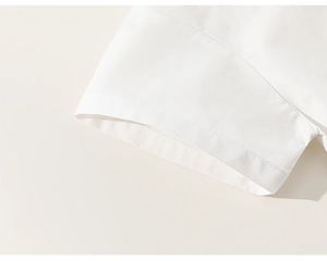Close-up of the neat stitching on white cotton short sleeve shirt cuff for boys