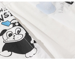 Close-up of boys white shirt featuring cartoon dog prints and classic button-up design
