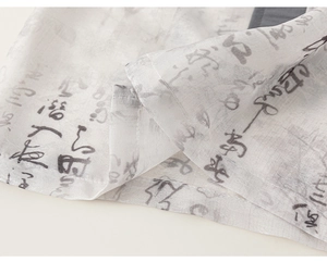 Détail de la chemise chinoise pour garçon montrant le tissu léger et l'imprimé calligraphie