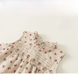 Detail of the ruffle collar with red bow print on this girl's beige summer cotton top