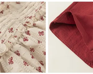 Detail view of cotton fabric with red bow print, pompom texture and fine stitching