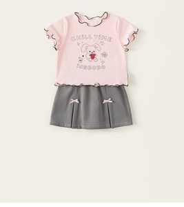 Detail von rosa T-Shirt mit Hasen-Print und grauem Faltenrock mit kleiner Schleife