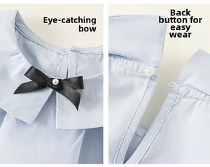 Détail chemise bébé fille avec col Claudine, nœud noir et fermeture à bouton arrière