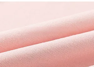 Nahaufnahme der rosa Baumwoll-Strickware mit weicher Textur für sommerliche Kinderkleidung