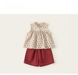 Detail view of floral sleeveless top with ruffle collar and red cotton linen shorts