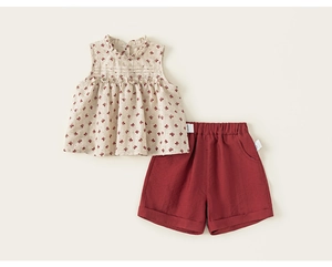 Detail of floral sleeveless top with ruffled collar and matching solid brick red shorts