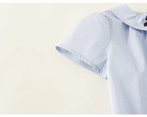 Vue détaillée du t-shirt bleu clair en coton pour fille avec col rond et nœud en ruban noir