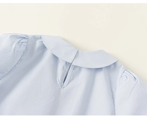 Détail du chemisier bleu clair pour filles avec col Claudine et ouverture goutte au dos