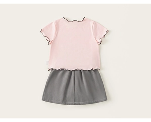 Detail von rosa Baumwoll-T-Shirt mit schwarzen Rüschenkanten und passendem Rock-Set