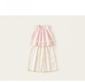 Détail du haut sans manches rose avec fleurs en dentelle et ensemble pantalon en coton