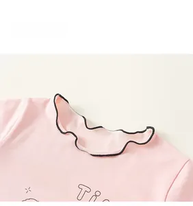 Detail eines rosa Baumwoll-T-Shirts mit Rüschenkragen und Sternen-Grafik-Druck
