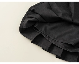 Gros plan détaillé du tissu noir plissé montrant la texture fine et les coutures de l'ourlet