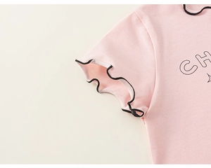 Detail eines rosa Mädchenoberteils mit Rüschenärmeln und schwarzer Overlock-Stichkante