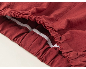 Detailed close-up of dark red cotton fabric with high-quality elastic waistband and stitching