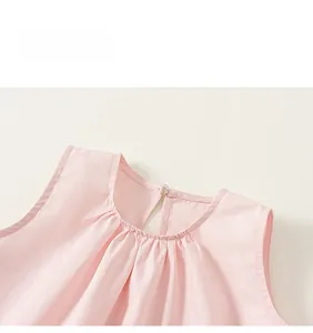 Détail de haut rose pour fille avec encolure plissée et fermeture à bouton au dos