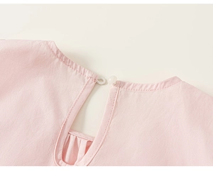 Détail du haut rose sans manches pour fille avec col rond et fermeture à bouton dos