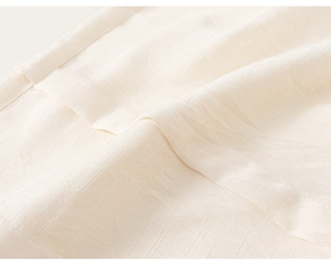 Gros plan sur le tissu en coton et lin beige montrant la texture fine et les coutures