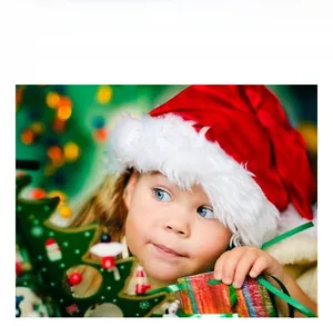 Close-up of child wearing a plush red and white Santa hat for Christmas festivities