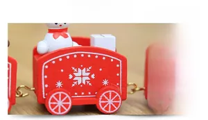 Detail view of red wooden Christmas train carriage with snowmen and white snowflake patterns