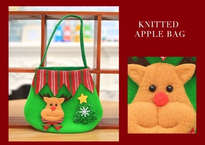 Close-up of a green knitted Christmas reindeer gift bag with 3D details and a small tree