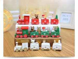Detail of wooden Christmas train sets with miniature snowmen and trees on a festive desk